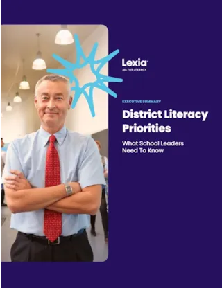Smiling man in a shirt and tie stands with arms crossed; text reads “District Literacy Priorities: What School Leaders Need to Know.”.