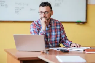 A man sitting at a desk with a laptop.