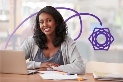 Smiling woman sits at a desk with a laptop, papers, and books, with a purple geometric graphic in the background.