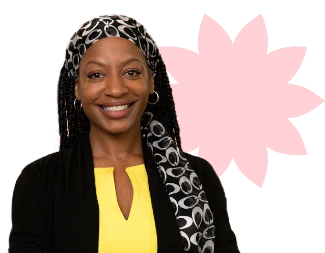 Smiling woman in a yellow top and patterned headscarf, standing in front of a red flower shape.