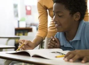 Teacher helping child read