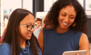 Teacher_Instructing_Student_In_Class_on_tablet