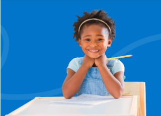 Smiling student at her desk holding a pencil and eager to learn