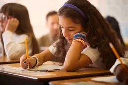 A student works intently on an assignment in a classroom