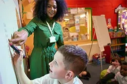 An educator instructs a student using a Smart Board