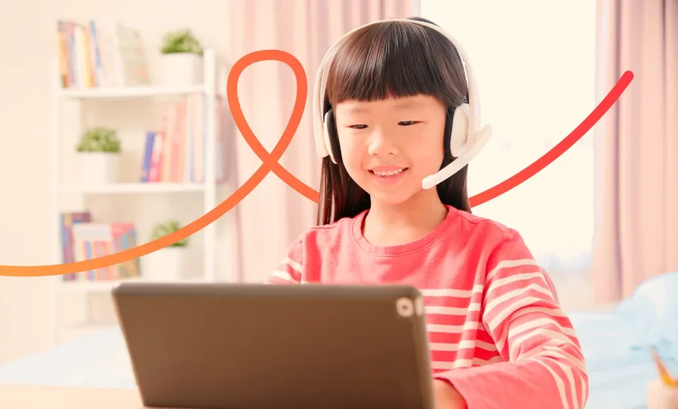 Young girl wearing a headset smiles while using a...