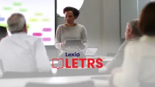 A woman holding a tablet speaks to three adults in a classroom; the Lexia LETRS logo is overlaid.