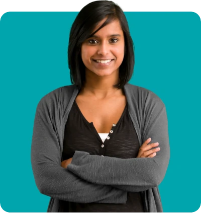 Woman with medium-length dark hair, wearing a gray cardigan, smiling with arms crossed against a teal background.