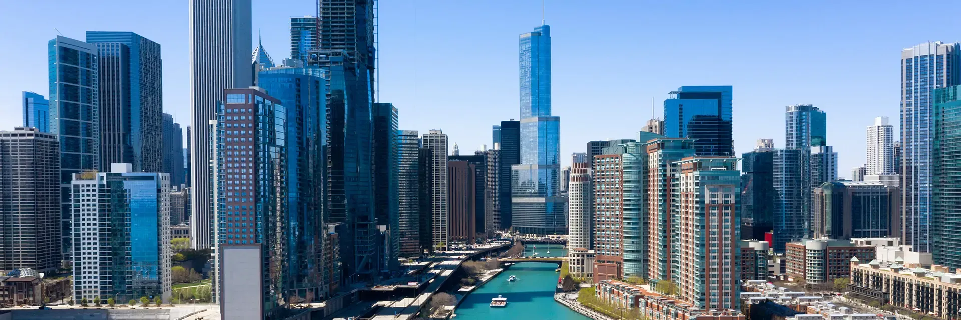 A cityscape of downtown Chicago with tall skyscrapers and the Chicago River running through the center.