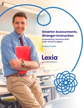 Smiling man in a blue shirt holds a red folder, standing in a classroom. Text reads Smarter Assessments, Stronger Instruction.
